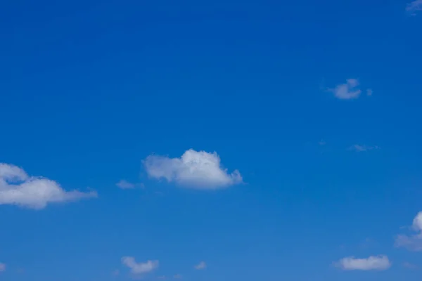 A small number of white clouds in the sky.