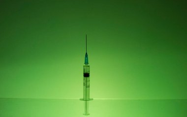 Yeşil duvara karşı duran bir şırınga..