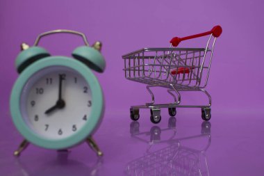 Bir süpermarket arabasının arka planındaki mavi saat..