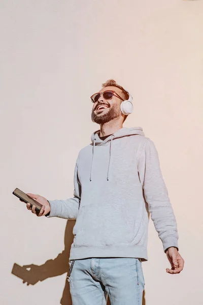 Young Man Laughing Looks His Phone Listens Music Neutral Background — Stock Photo, Image