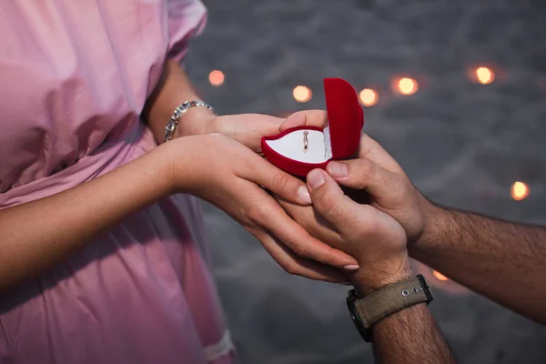 Young man is presenting engagement ring to his girlfriend.