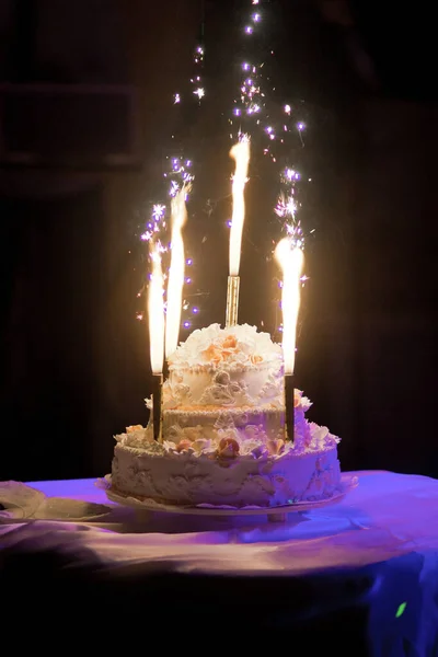 Wedding cake with candles and fireworks light — Stock Photo, Image