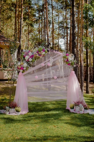 Bröllop valv med blommor arrangerade i parken för en bröllopsceremoni Royaltyfria Stockfoton