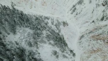 Kanyonun tepesinden hava görüntüsü. Kameralar yavaşça 90 dereceye doğru eğiliyor. Dağlı son bir panorama için. Karla kaplı bir kanyonun kuş bakışı görüntüsü.