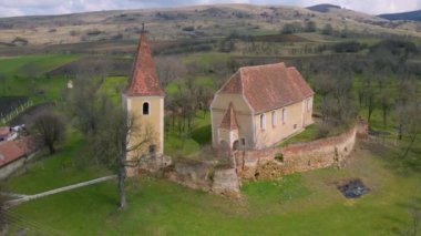 Eğik kulesi ve kalın duvarları olan terk edilmiş eski bir kilisenin klibi. Ürkütücü bir kilisenin insansız hava aracı görüntüleri..