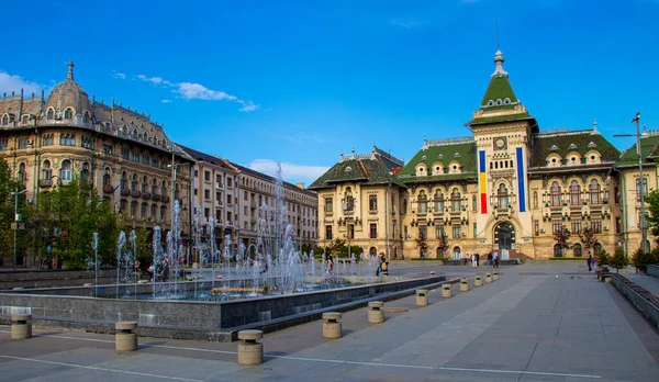 304.04.2021 Craiova, Romanya. Mihai Viteazu Meydanı 'ndaki çeşmenin ve arkadaki Craiova Belediye Binasının fotoğrafları..