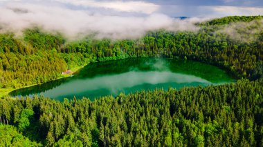 Saint Ann Volkanik Gölü 'nün Romanya, Harghita' daki hava fotoğrafları. Fotoğraf, gölün yukarısındaki kameralı bulutlarla aynı yükseklikteki bir İHA 'dan çekildi..