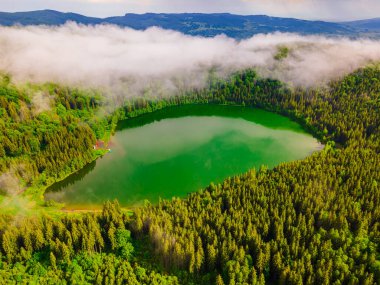 Saint Ann Volkanik Gölü 'nün Romanya, Harghita' daki hava fotoğrafları. Fotoğraf, gölün yukarısındaki kameralı bulutlarla aynı yükseklikteki bir İHA 'dan çekildi..