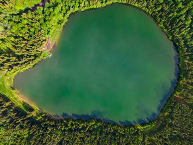 Romanya, Harghita 'da bulunan Saint Ana volkanik gölünün hava fotoğrafları. Fotoğraf makinesi aşağıya bakan bir İHA 'dan çekildi. Yukarıdan mavi renkli bir gölün fotoğrafı