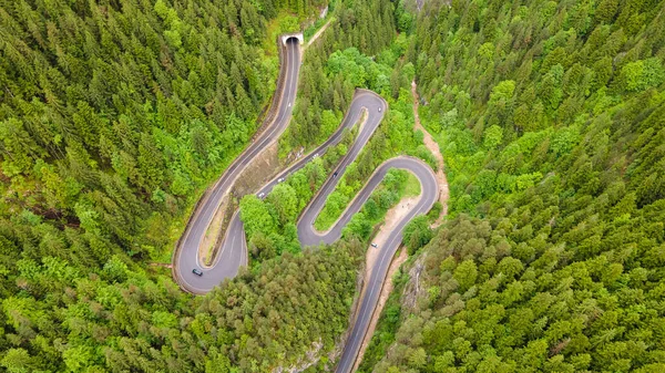 Winding road in the mountains, shot from a drone from a higher altitude and a low camera angle. Photography of a serpentine road in the mountains.
