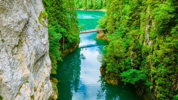 Aerial view over a beautiful turquoise colored water with cliffs on both sides. Photography was taken from a drone at Scropoasa lake located in Romania.