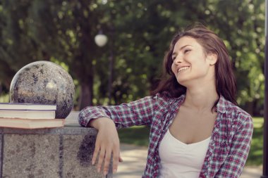 Bir parkta duran ve neşeyle gülerek öğrenci.