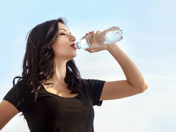 Flicka dricksvatten från en flaska — Stockfoto