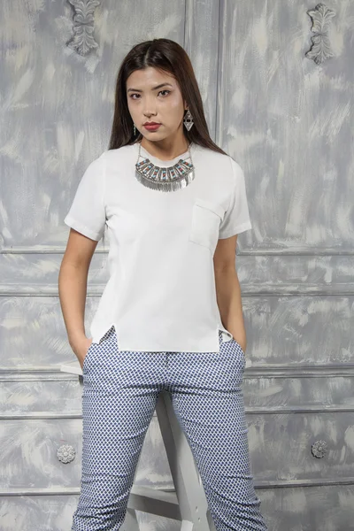 Menina asiática vestida com uma camisa branca e calças azuis — Fotografia de Stock