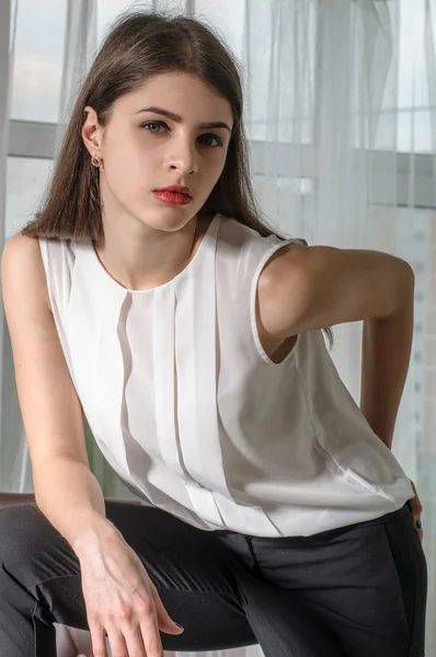 Flicka poserar i office. Hon bär smarta kläder. — Stockfoto