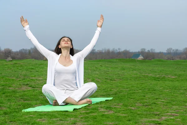 Mulher de branco fazendo exercício de ioga — Fotografia de Stock