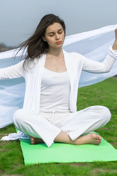 Žena v bílém cvičí jógu — Stock fotografie