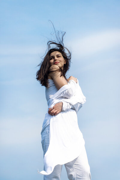 Girl stands on the background of the sky