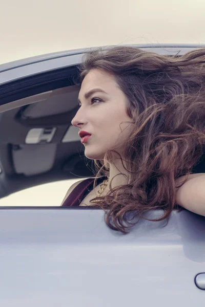 Woman looks out the car window — Stock Photo, Image