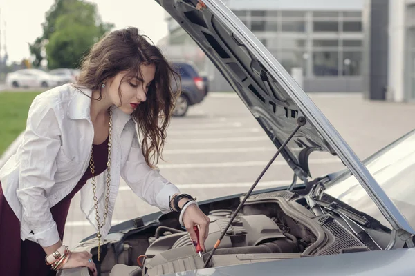 Девушка пытается починить машину . — стоковое фото