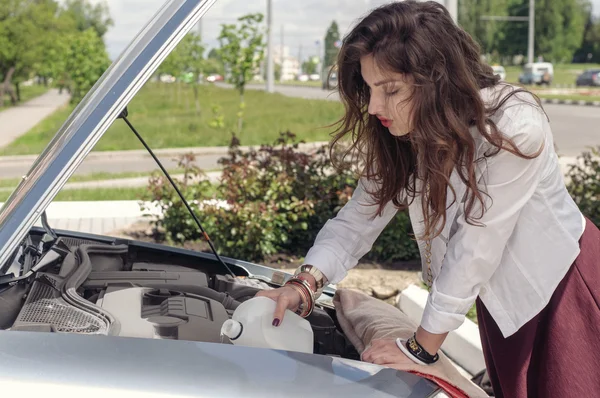 Woman opened the hood and she pours liquid — Stock Photo, Image