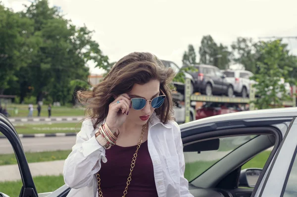 Femme en lunettes de soleil hors de la voiture — Photo