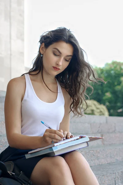 Girl with books sitting on the steps — Stock Photo, Image