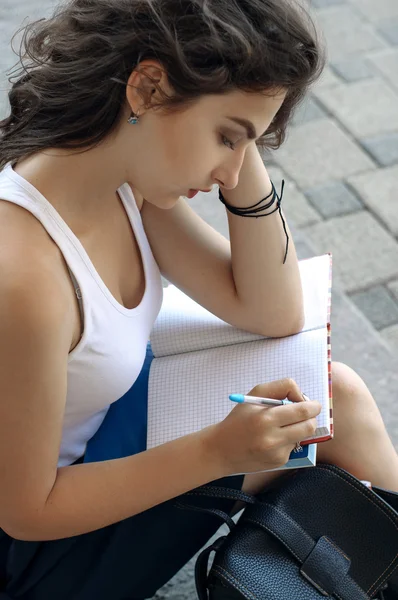 Girl with books sitting on the steps — Stock Photo, Image