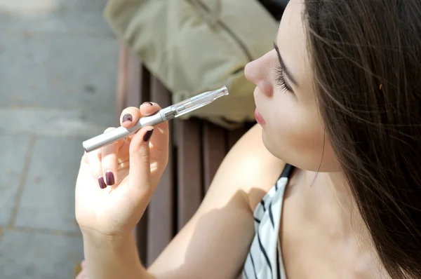 Menina fuma um cigarro eletrônico — Fotografia de Stock