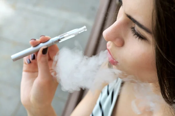 Ragazza fuma una sigaretta elettronica — Foto Stock
