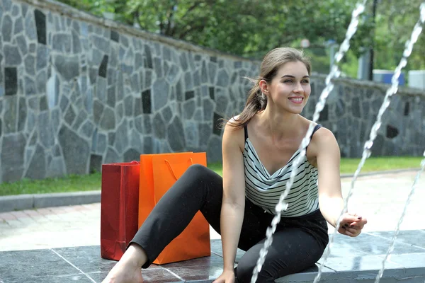 Chica sentada cerca de una fuente — Foto de Stock