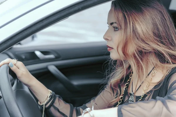 Mulher está dirigindo um carro — Fotografia de Stock