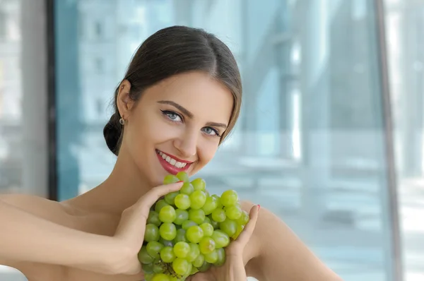 Girl is holding a bunch of ripe grapes in her hands — Stock Photo, Image