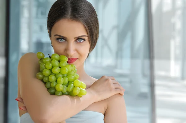 Beautiful turkish woman holding a bunch of grapes