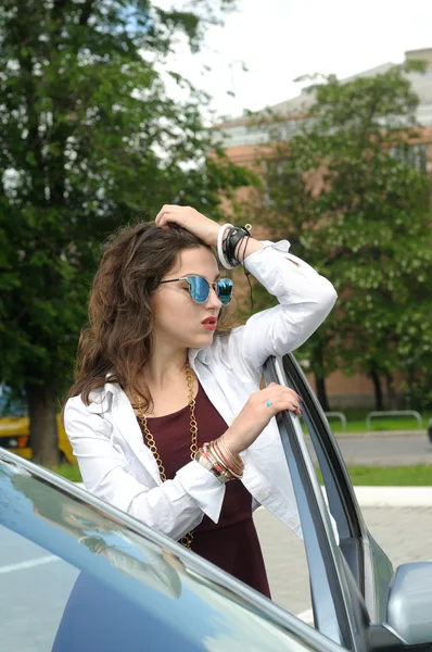 Chica se apoya en la puerta de su coche — Foto de Stock