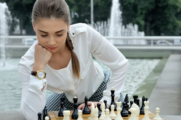 Женщина, потерявшаяся в мыслях во время игры в шахматы — стоковое фото