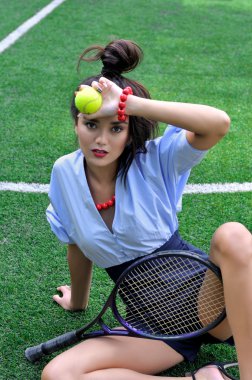 Woman sitting on the court with racket