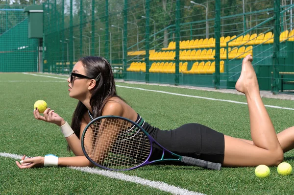 Chica se encuentra en un jugador de tenis de hierba con una raqueta — Foto de Stock