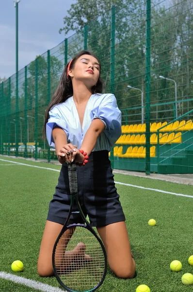 Mujer arrodillada en la cancha de tenis confiando en la raqueta . — Foto de Stock