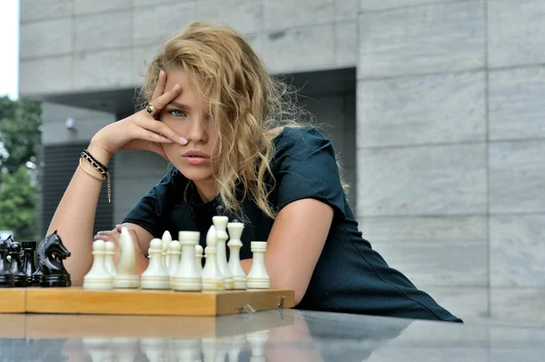 Женщина сидит на противоположных шахматных фигурах — стоковое фото
