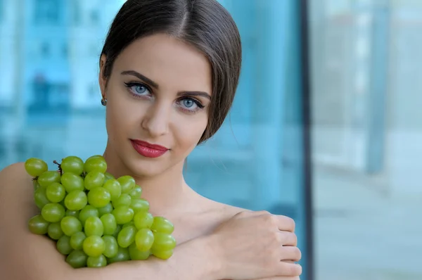 Girl holding grapes on the chest and hugs it — Stock Photo, Image