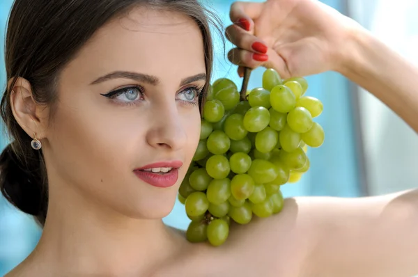 Girl put a bunch of green grapes on her left shoulder — Stock Photo, Image