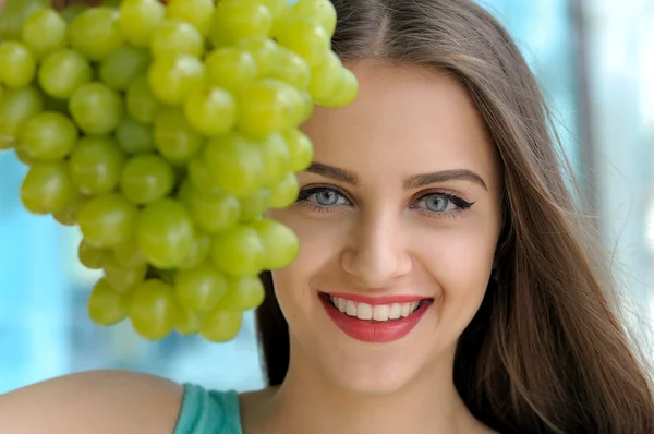 Portrait of a girl behind bunch of ripe grapes — Stock Photo, Image