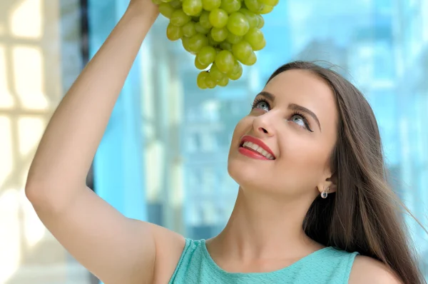 Girl holding a large bunch of grapes — Stock Photo, Image