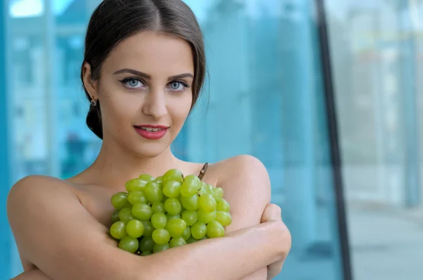 Girl put a bunch of grapes on her chest — Stock Photo, Image