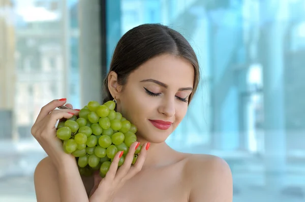 Girl holding a large bunch of ripe grapes — Stock Photo, Image