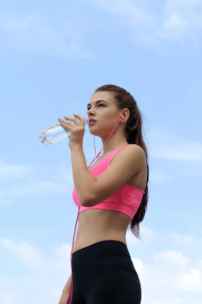 Visão inferior de uma menina no sportswear bebe água — Fotografia de Stock