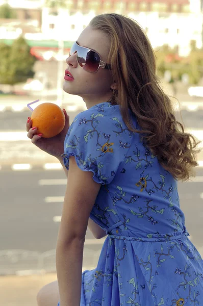 Chica sostiene una naranja en sus manos — Foto de Stock