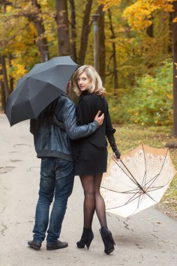 Erkek ve kadın şemsiye altında yürümek