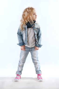 Küçük kız kot takım elbise ve uzağa bakarak pembe spor ayakkabı 